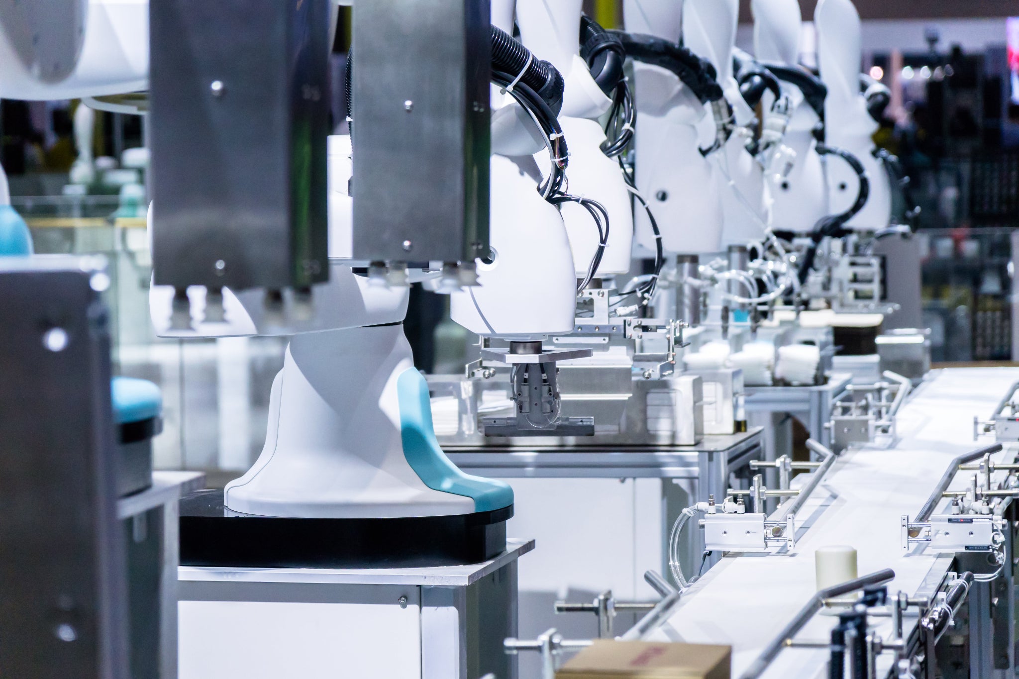 Robotic arms in a manufacturing setting with a focus on automation.