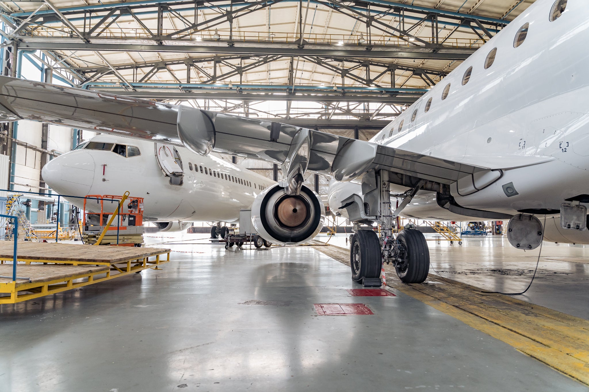 Airplane inside a large hangar with visible infrastructure
