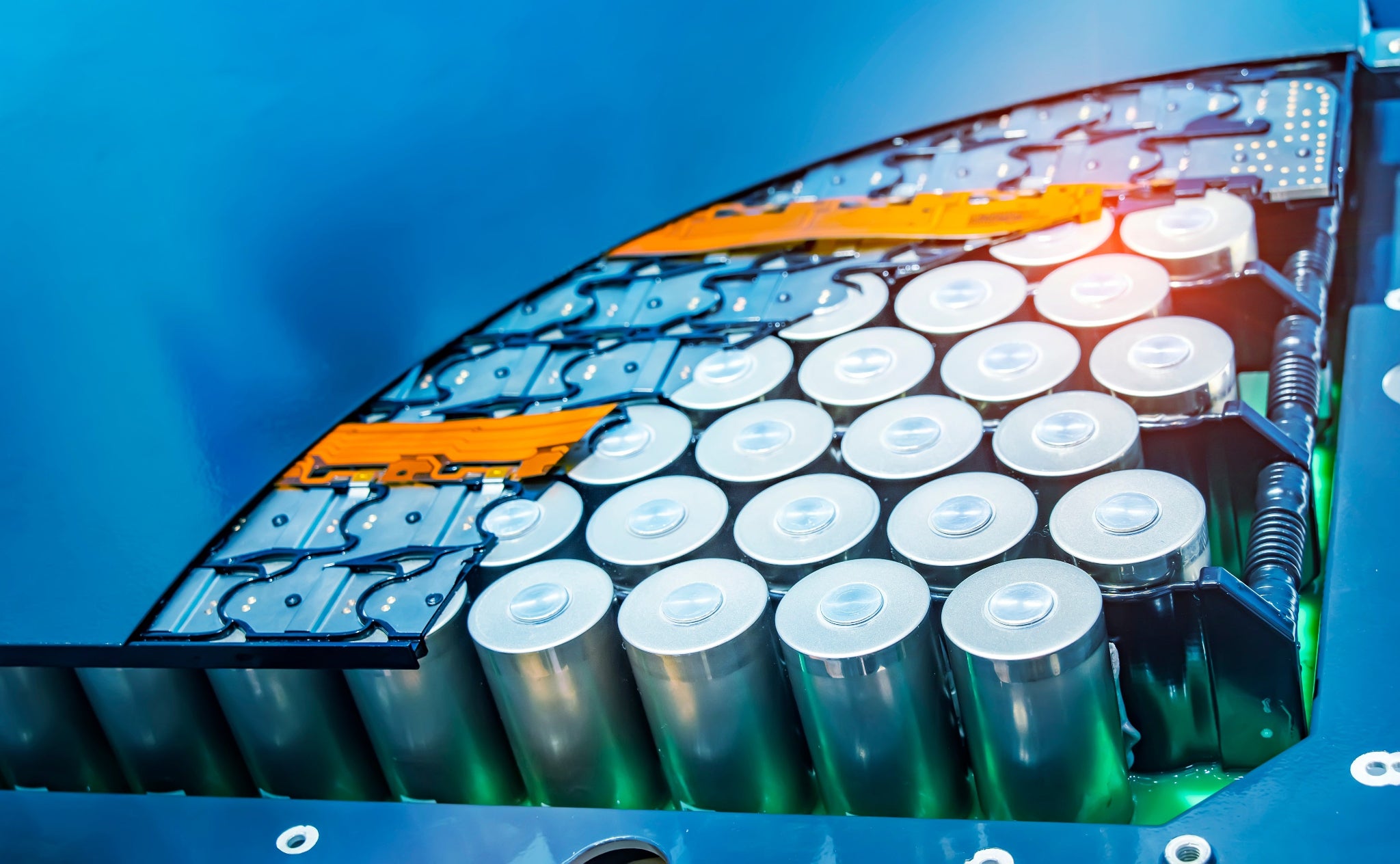 Close-up of a battery pack with cylindrical cells on a blue background