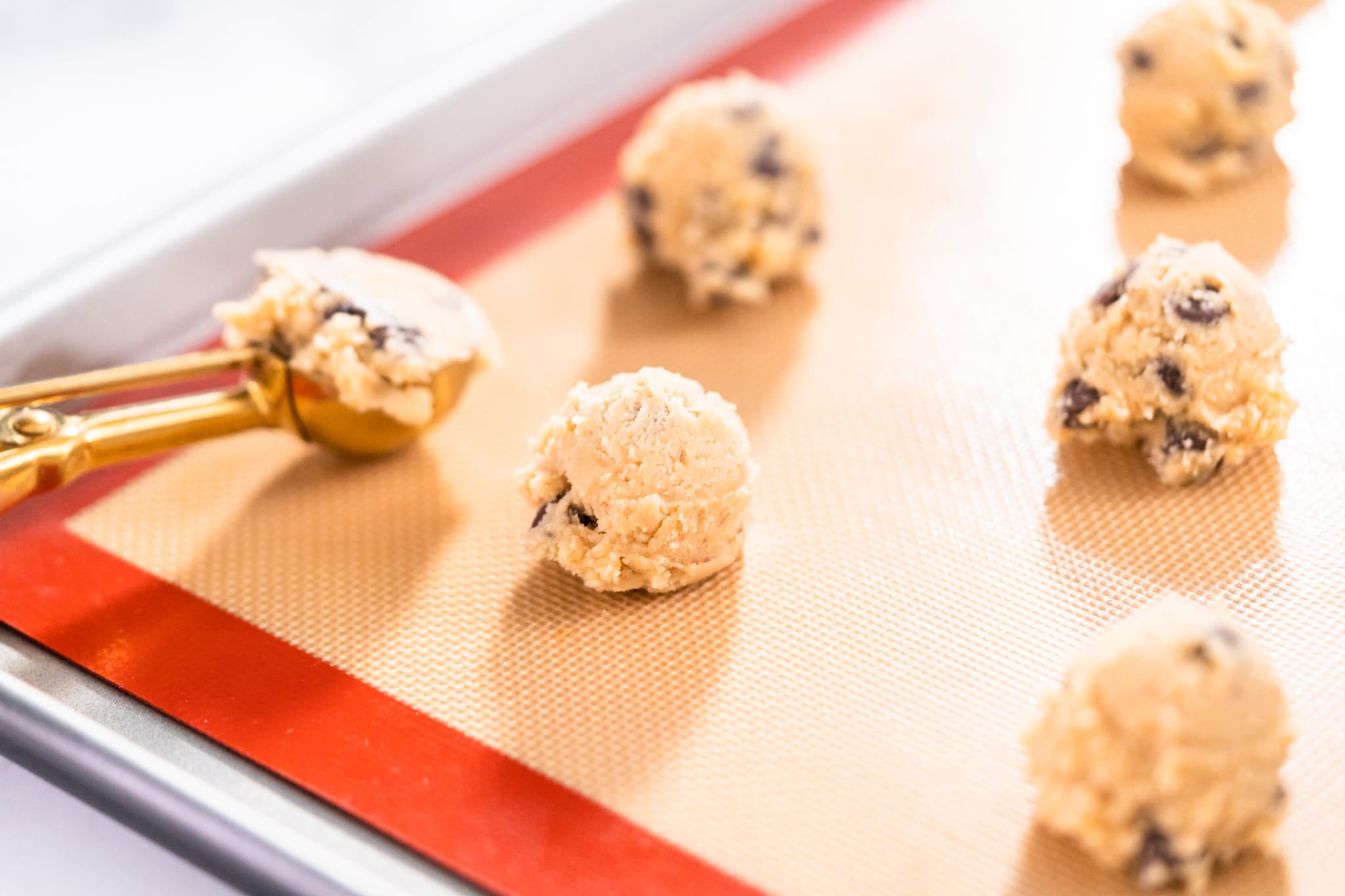 Cookie dough balls on a baking sheet with a red border