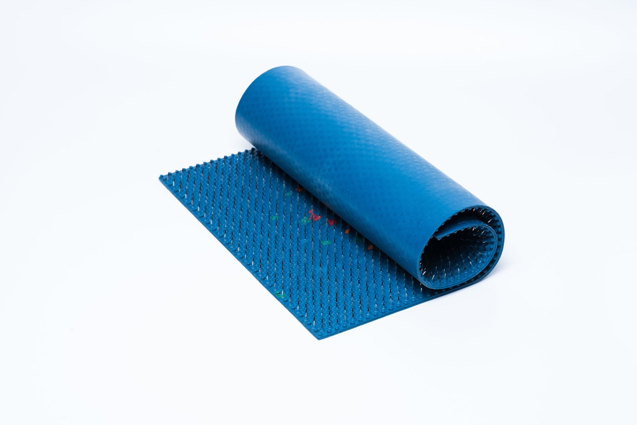Blue textured mat with rolled-up section on a white background