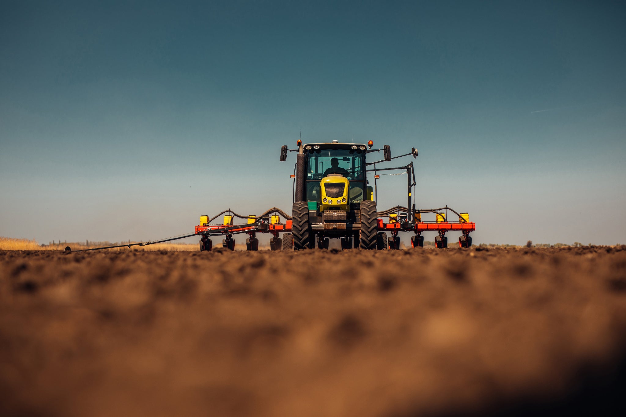 Tractor in a field with a clear sky